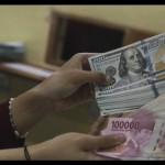 Ilustrasi: Petugas menunjukkan uang pecahan Rp100.000 dan 100 dolar AS di jasa penukaran uang asing di Jakarta. ANTARA FOTO/Rivan Awal Lingga/rwa.-1670901671