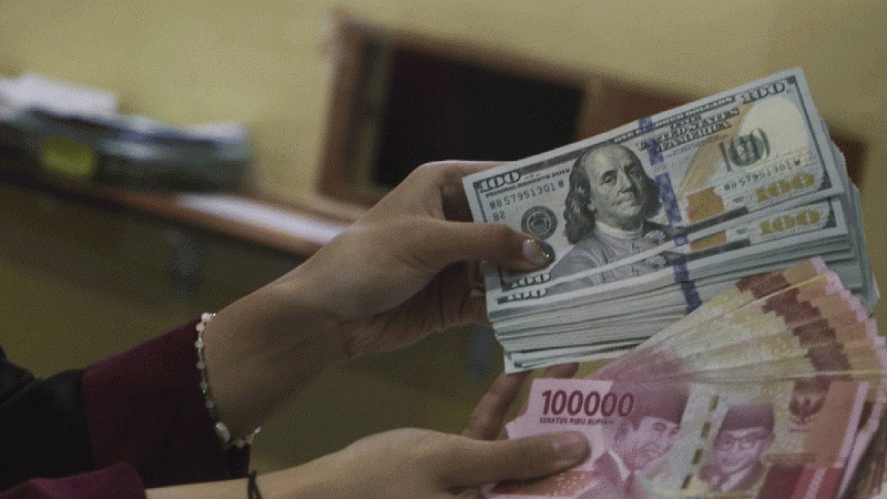 Ilustrasi: Petugas menunjukkan uang pecahan Rp100.000 dan 100 dolar AS di jasa penukaran uang asing, Jakarta. ANTARA FOTO/Rivan Awal Lingga/rwa.