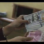 Ilustrasi: Petugas menunjukkan uang pecahan Rp100.000 dan 100 dolar AS di jasa penukaran uang asing, Jakarta. ANTARA FOTO/Rivan Awal Lingga/rwa.-1670295831