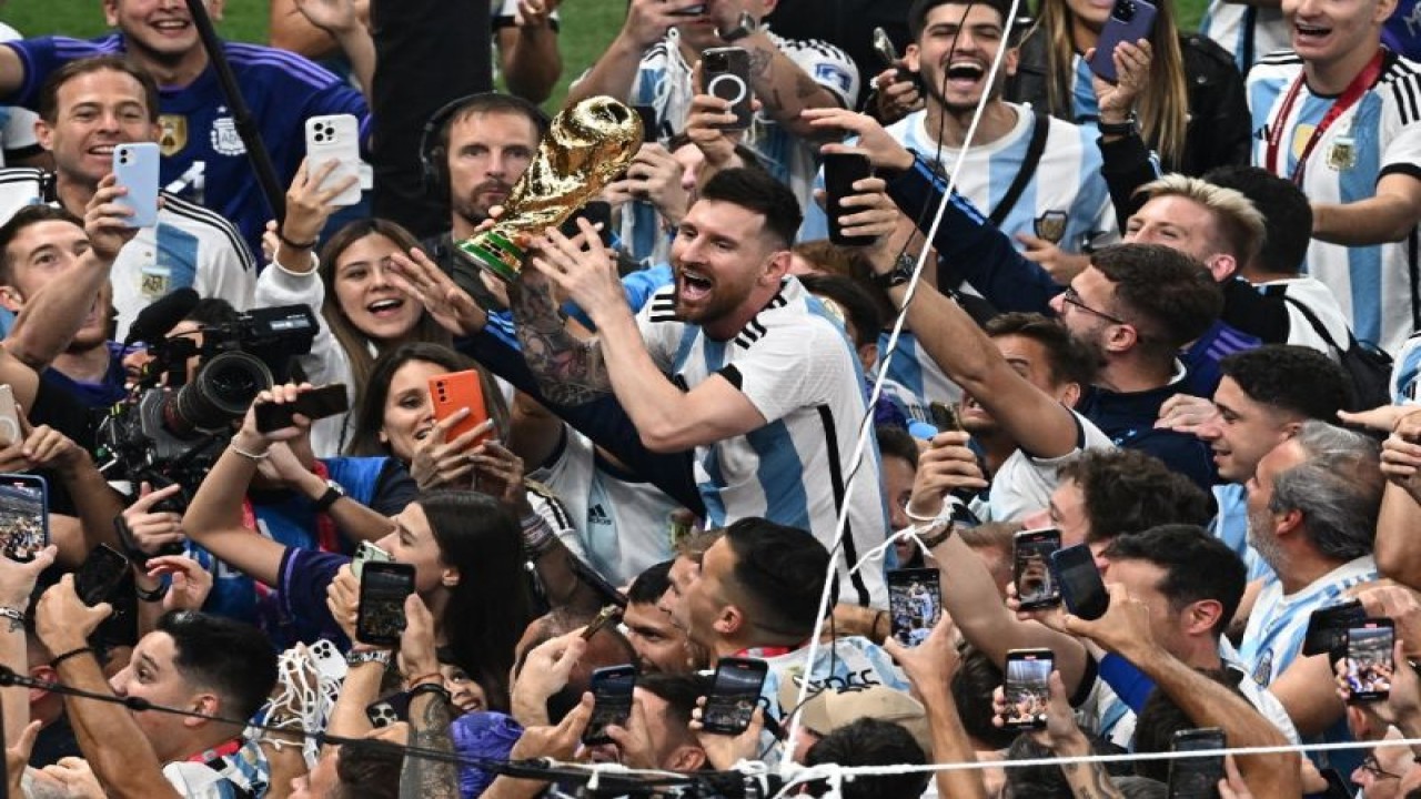 Kapten timnas Argentina Lionel Messi menggenggam trofi Piala Dunia dalam selebrasi bersama rekan-rekan satu tim setelah final Piala Dunia Qatar 2022 antara Argentina dan Prancis di Stadion Lusail, Qatar, 18 Desember 2022. (Photo by Jewel SAMAD / AFP) (AFP/JEWEL SAMAD)