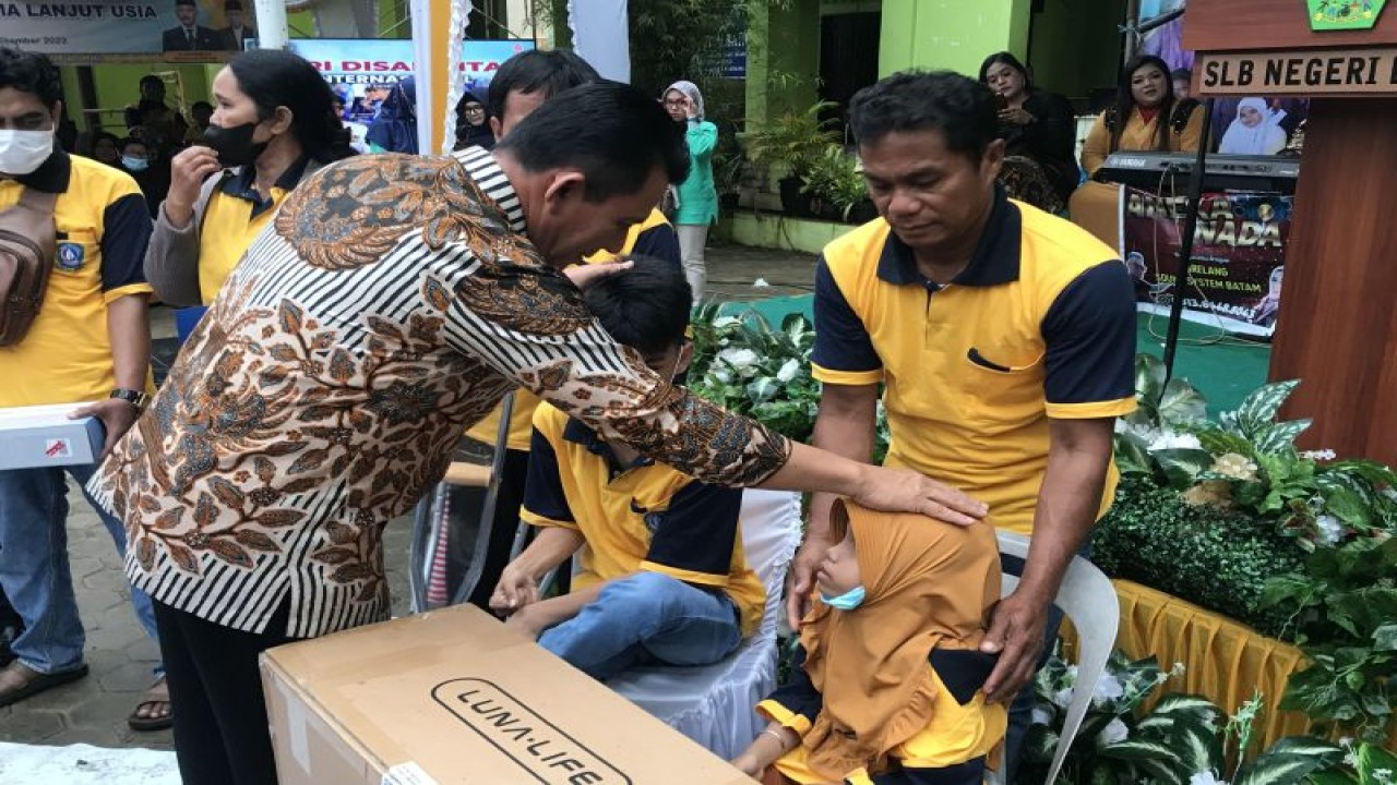 Gubernur Kepri Ansar Ahmad memberikan bantuan berupa kursi roda kepada salah satu penyandang disabilitas di Kota Batam, Kamis (8/12). (ANTARA/Yude)
