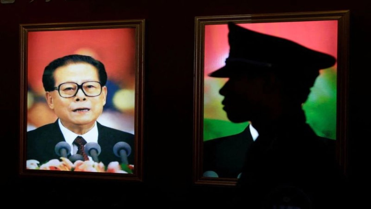 Arsip - Seorang penjaga keamanan berdiri di samping potret mantan Presiden China Jiang Zemin di sebuah pameran untuk merayakan peringatan 90 tahun berdirinya Partai Komunis China (CPC) di Beijing, China, 7 Juli 2011. (ANTARA/REUTERS/Jason Lee/as)