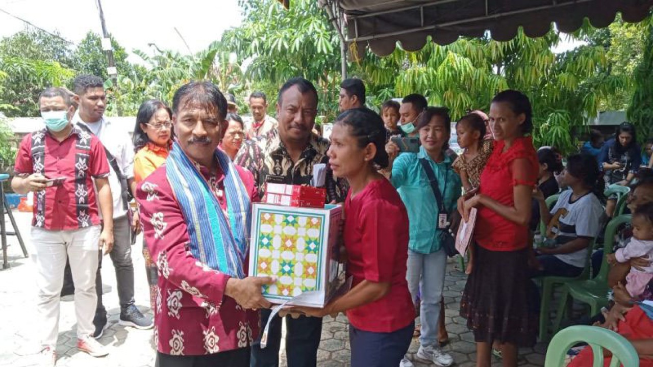 Penjabat Wali Kota Kupang Provinsi Nusa Tenggara Timur George Melkianus Hadjoh (kiri) menyerahkan bantuan makanan tambahan kepada warga Kelurahan Naimata guna mengatasi kekerdilan, Kamis (ANTARA/Benny Jahang)