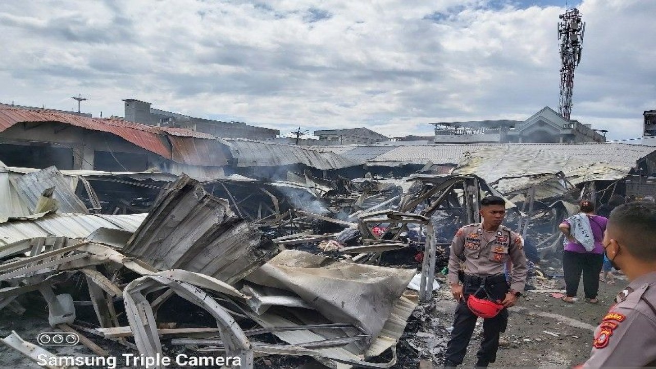 Para petugas kebersihan bersama para pedagang Pasar Masomba Palu bergotong royong membersihkan materil barang yang terbakar pada Rabu malam (30/11) untuk diangkut ke mobil pengangkut sampah di Pasar Masomba Palu, Kamis (01/12/2022). ANTARA/La Ode Masrafi.