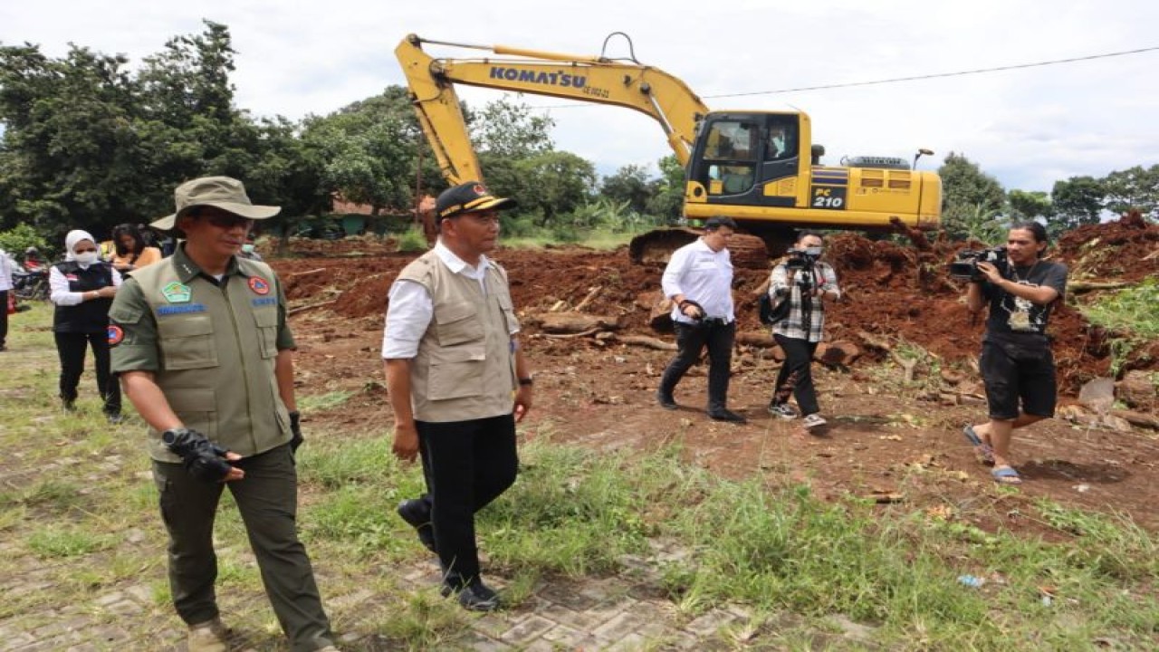 Kepala BNPB Letjen TNI Suharyanto (kemeja hijau dengan rompi) dan Menko PMK Muhadjir Effendy (kemeja putih dengan rompi) meninjau salah satu lokasi lahan relokasi bagi warga terdampak gempa di Kabupaten Cianjur, Jawa Barat pada Rabu (30/11/2022). (Antara/HO-BNPB)