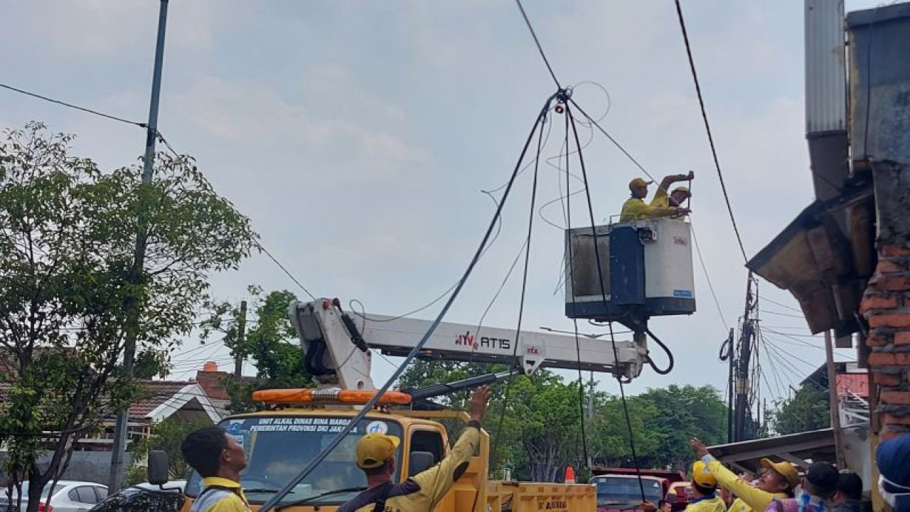 Petugas Dinas Bina Marga DKI Jakarta melakukan pemotongan kabel udara di Jalan Jatinegara Kaum, Jakarta, Kamis (1/12/2022). ANTARA/Yogi Rachman