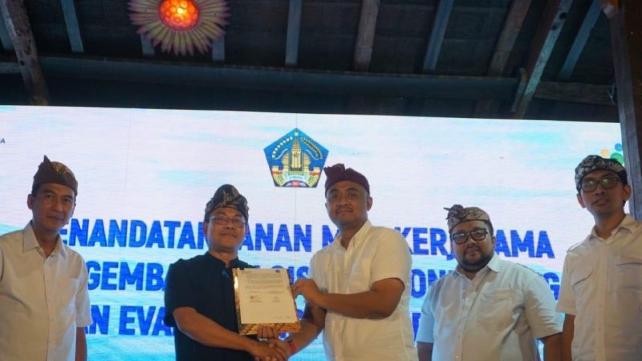 Direktur Transformasi PT Pupuk Indonesia (Persero) Panji Winanteya Ruky dan Kepala Dinas Pertanian dan Ketahanan Pangan Provinsi Bali Wayan Sunada menunjukkan MoU yang telah ditandatangani di Denpasar, Kamis (29/12/2022). ANTARA/Ni Luh Rhismawati.