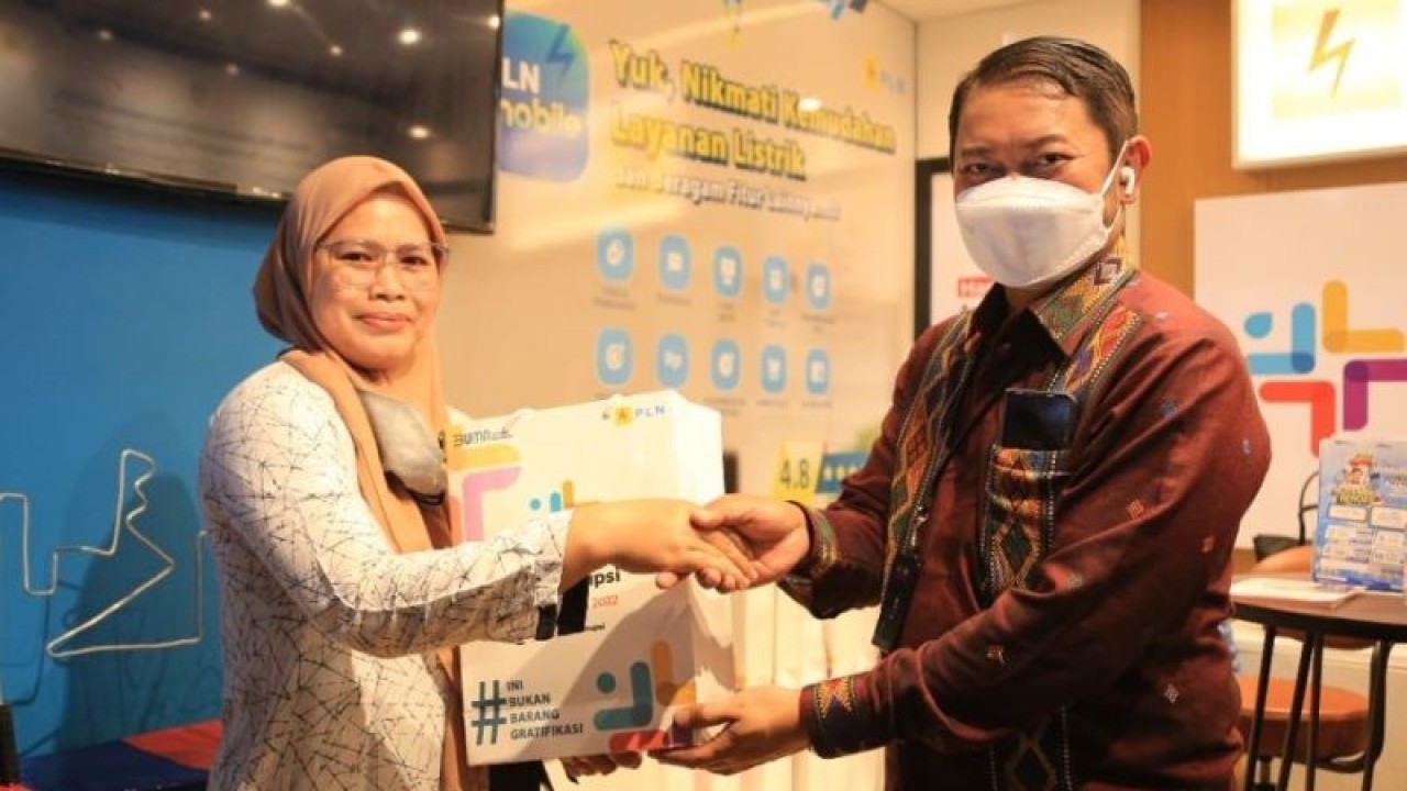 ​​​​​​​General Manajer UID Sumatera Utara Tonny Belamy ( kanan) menyerahkan hadiah kepada salah seorang pengunjung yang berpartisipasi di games pada booth PLN. (Foto:ANTARA/HO/PLN Sumut)