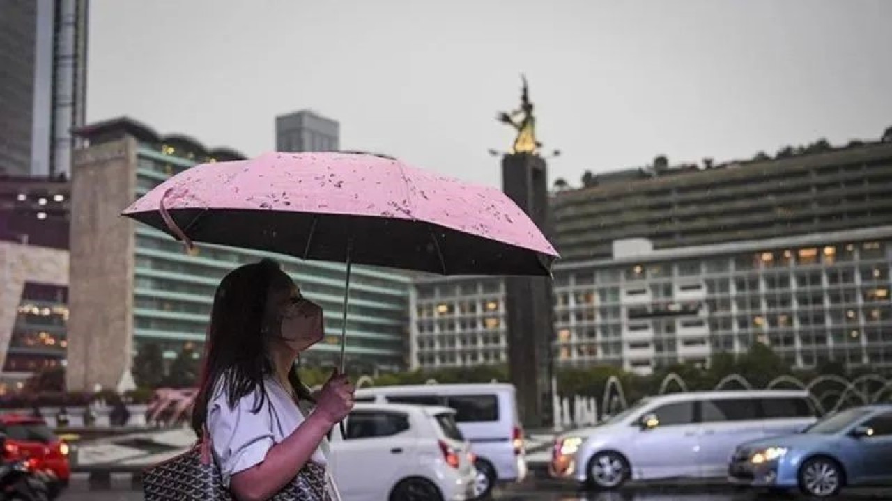 Arsip foto - Seorang warga menggunakan payung saat turun hujan di kawasan Bundaran Hotel Indonesia, Jakarta, Selasa (4/10/2022). (ANTARA FOTO/M Risyal Hidayat/tom/pri.) (ANTARA FOTO/M Risyal Hidayat/tom/pri.)