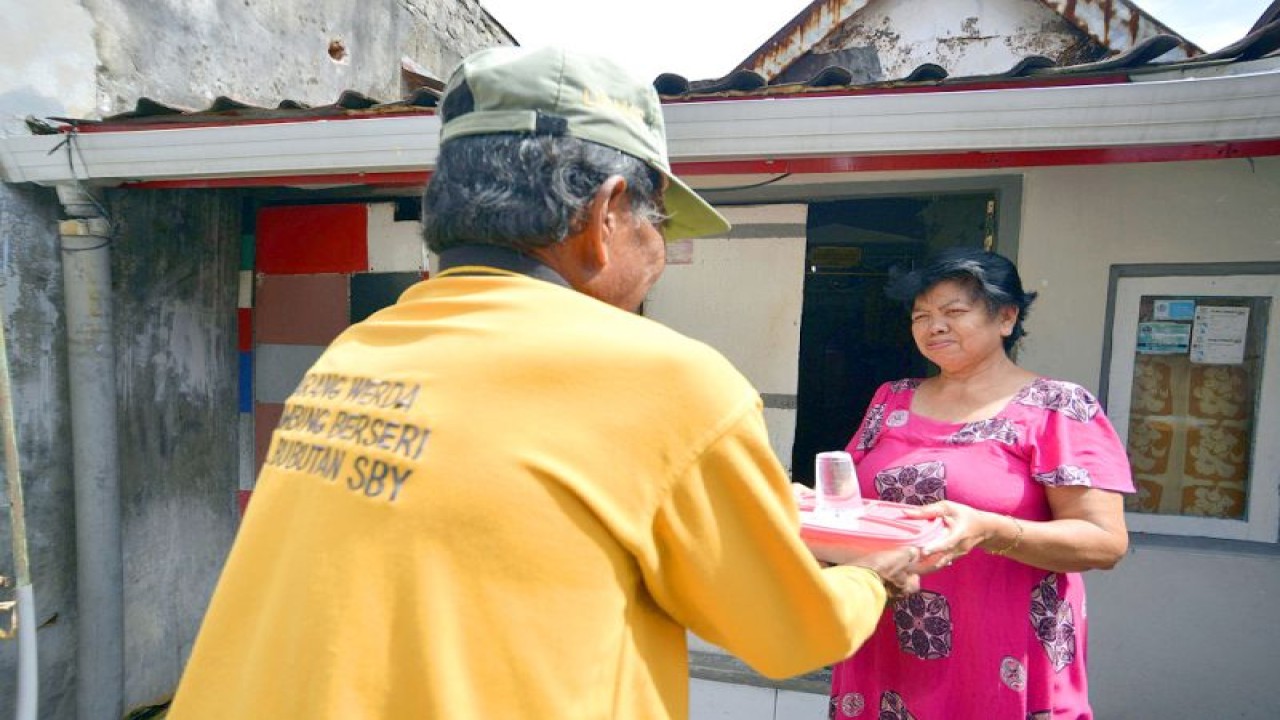 Foto Arsip - Salah seorang petugas dinas sosial memberikan bantuan makanan kepada lansia di Kota Surabaya. (ANTARA/HO-Diskominfo Surabaya)