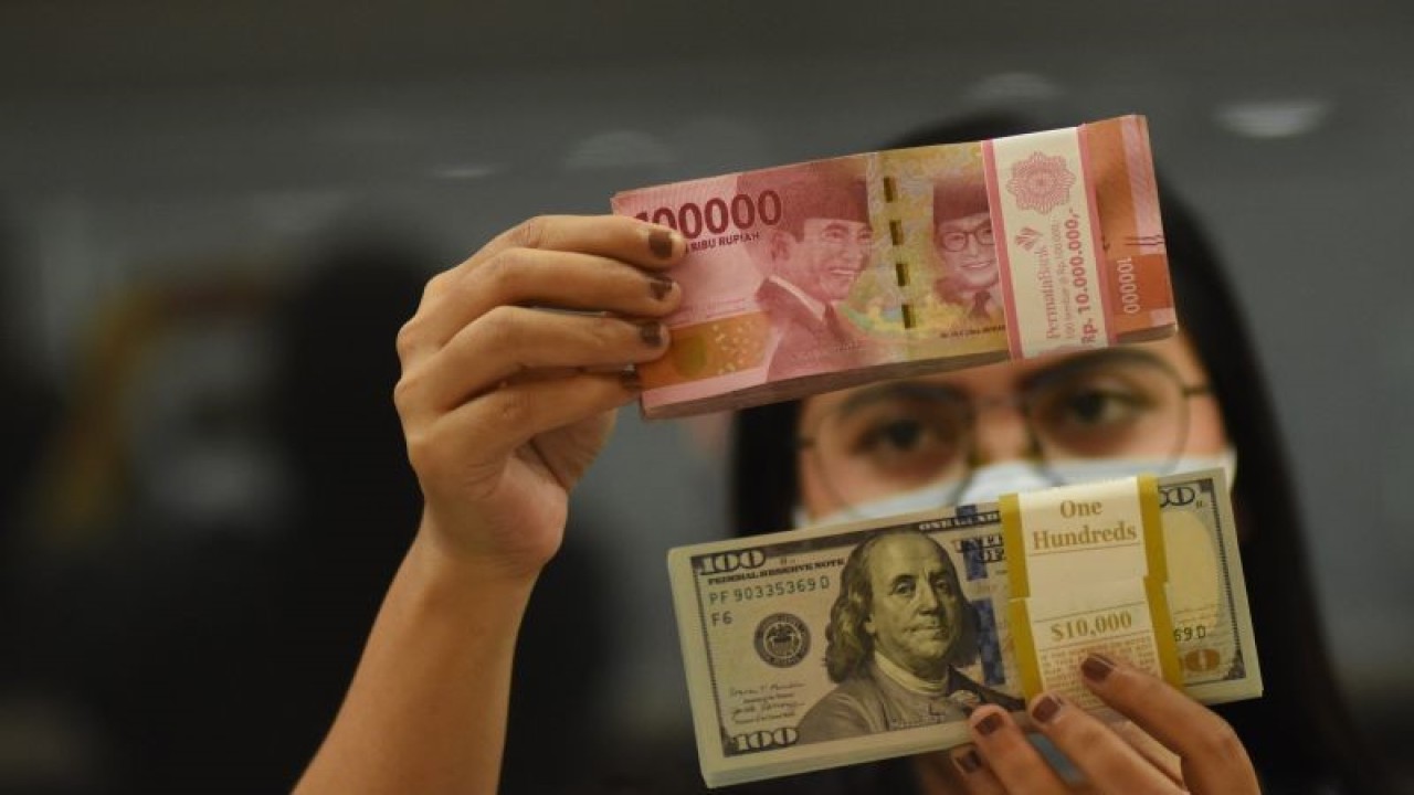 Ilustrasi - Pegawai menunjukkan mata uang rupiah dan dolar AS di salah satu gerai penukaran mata uang di Jakarta, ANTARA FOTO/Indrianto Eko Suwarso/YU/aa.