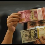 Ilustrasi - Pegawai menunjukkan mata uang rupiah dan dolar AS di salah satu gerai penukaran mata uang di Jakarta, ANTARA FOTO/Indrianto Eko Suwarso/YU/aa.-1672625824