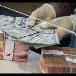 Ilustrasi - Petugas menghitung uang dolar AS di BNI KC Mega Kuningan, Jakarta. ANTARA FOTO/Rivan Awal Lingga/tom/pri.-1674189700