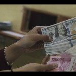 Ilustrasi: Petugas menunjukkan uang pecahan Rp100.000 dan 100 dolar AS di jasa penukaran uang asing di Jakarta. ANTARA FOTO/Rivan Awal Lingga/rwa.-1672721983