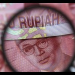 Ilustrasi - Uang kertas seratus ribu rupiah terlihat melalui kaca pembesar dalam ilustrasi foto yang diambil di Singapura, 14 Maret 2013. ANTARA/REUTERS/Edgar Su/pri.-1672892830