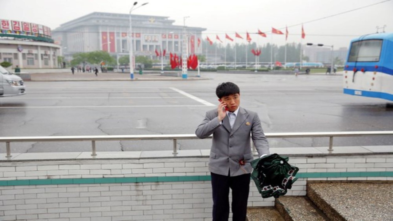 Seorang pria berbicara melalui ponsel di depan Gedung Kebudayaan 25 April, tempat kongres Partai Buruh Korea di Pyongyang, Korea Utara. (Reuters)