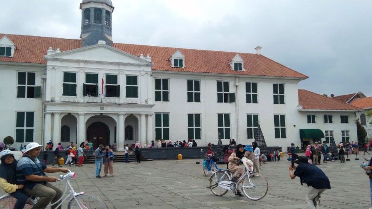 Wisatawan berfoto dengan latar belakang Museum Fatahillah di kawasan Kota Tua, Jakarta Barat, Sabtu (24-12-2022). ANTARA/Dewa Ketut Sudiarta Wiguna