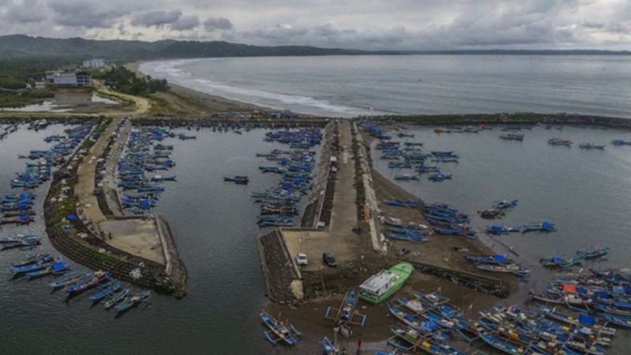 Foto udara sejumlah kapal nelayan bersandar di Pelabuhan Perikanan Cikidang, Kabupaten Pangandaran, Jawa Barat, Rabu (8/1/2020). Sebagian nelayan di daerah tersebut memilih tidak melaut akibat cuaca buruk dan tingginya ombak dalam sepekan terakhir, sehingga beralih profesi menjadi pemandu wisata serta jasa sewa perahu wisata. (ANTARA JABAR/Adeng Bustomi/agr)
