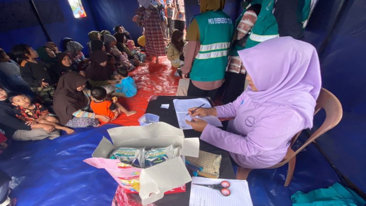 Seorang bidan mendata tumbuh kembang balita korban gempa Cianjur, Jawa Barat untuk diberikan biskuit sebagai PMT anak. (ANTARA/Hreeloita Dharma Shanti)