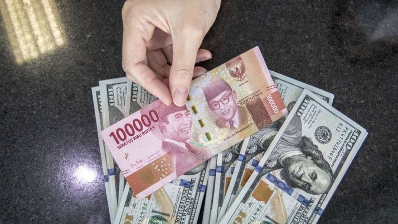 Ilustrasi - Petugas menunjukan uang pecahan Rupiah dan dolar AS di gerai penukaran mata uang asing VIP (Valuta Inti Prima) Money Changer, Jakarta, Selasa (4/10/2022). ANTARA FOTO/Muhammad Adimaja/aww/pri.