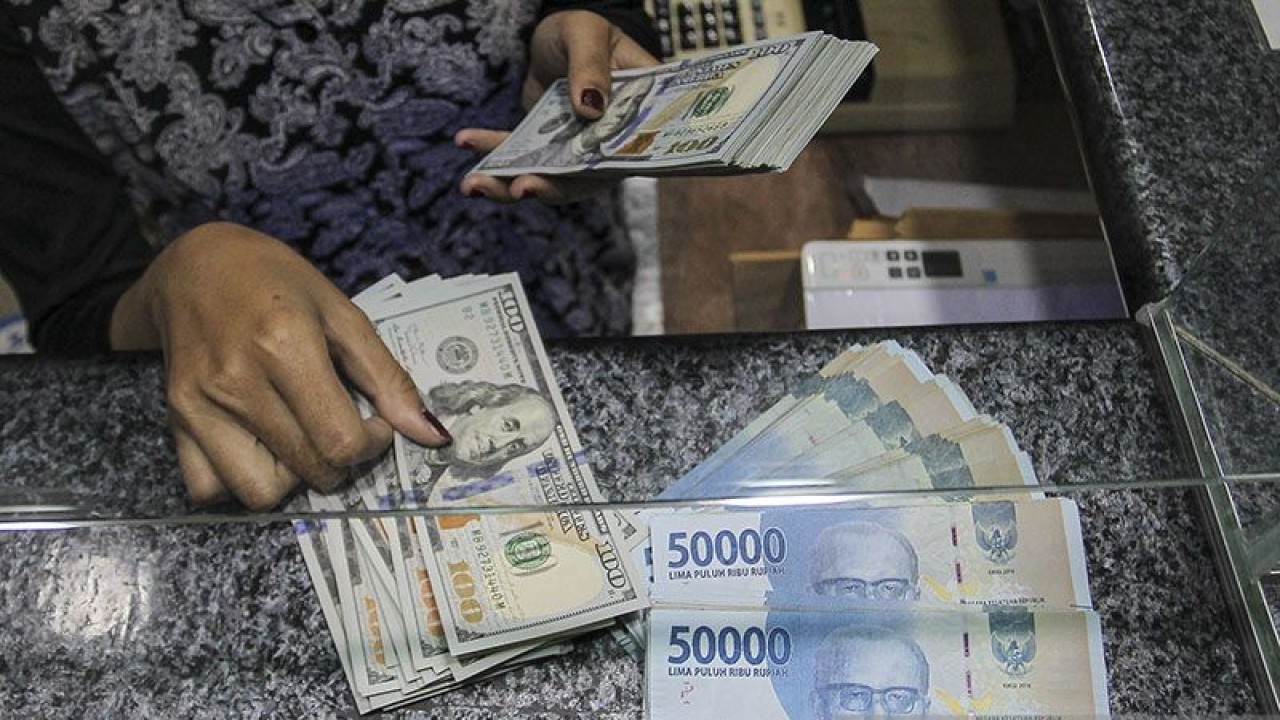 Pekerja menghitung uang dolar AS di salah satu gerai penukaran mata uang di Jakarta, Rabu (5/1/2022). ANTARA FOTO/Dhemas Reviyanto/wsj.