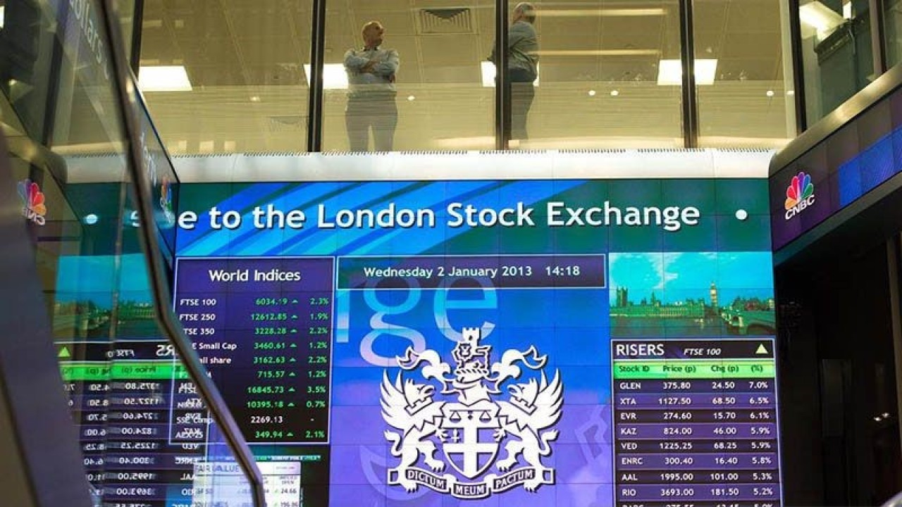 Pekerja terlihat berbincang di atas papan elektronik pergerakan saham di London Stock Exchange, Inggris. REUTERS/Paul Hackett/aa. (REUTERS/Paul Hackett)