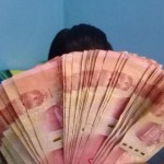 Seorang pegawai kantor meunjukkan uang dengan nominal Rp100 ribu di Kupang, NTT, Selasa (17/01/2023)/ ANTARA/Kornelis Kaha-1673925157