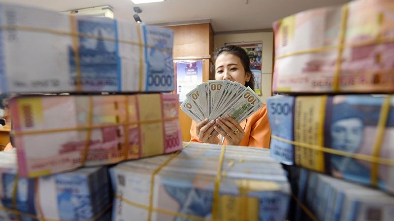 Seorang wanita menghitung uang transaksi penukaran Dollar AS dengan Rupiah di Jakarta. ANTARA FOTO/Akbar Nugroho Gumay/Rei/foc/15.