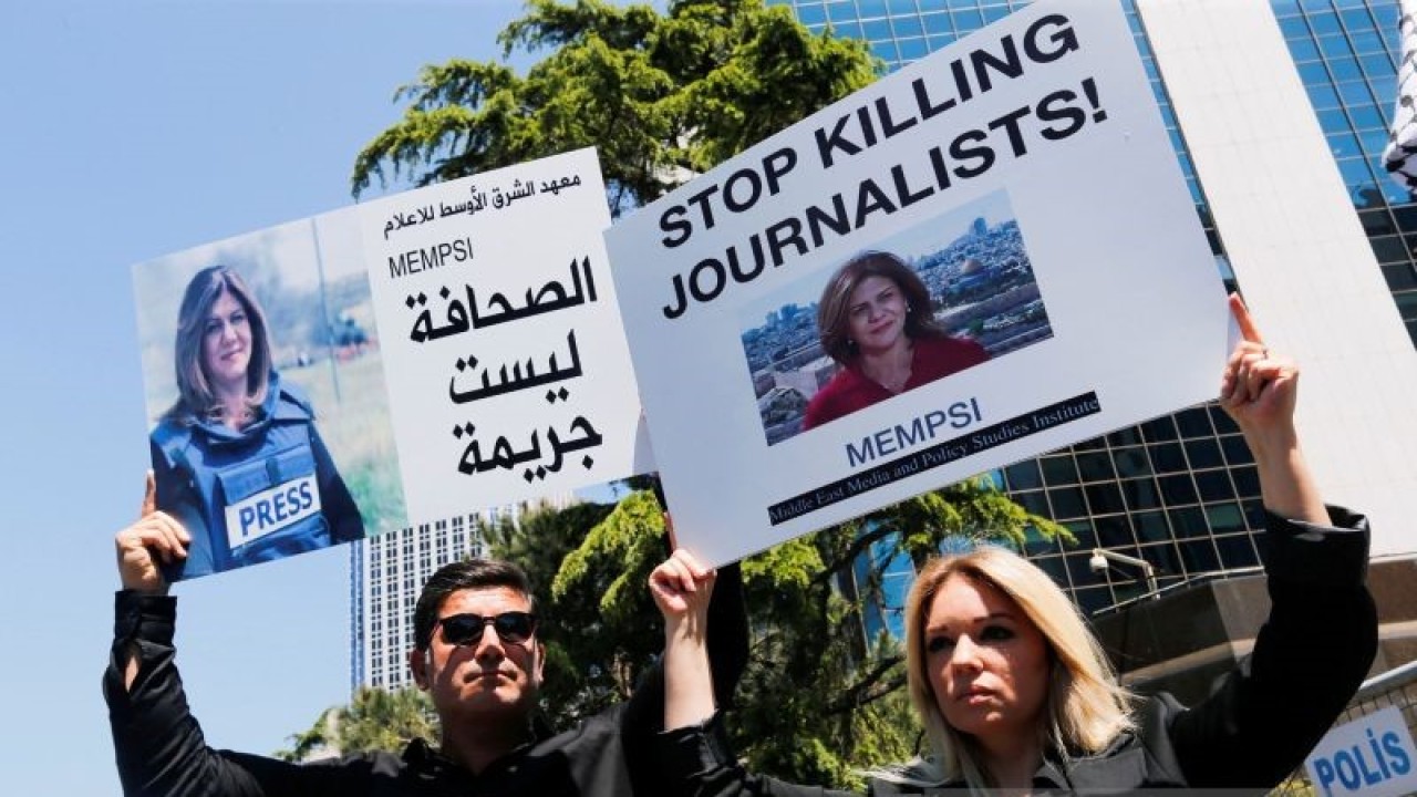 Pengunjuk rasa pro Palestina membawa spanduk dengan gambar jurnalis Al Jazeera Shireen Abu Akleh, yang tewas dalam serbuan Israel di Jenin, selama aksi protes di depan konsulate Israel, di Istambul, Turki, Kamis (12/5/2022). ANTARA FOTO/REUTERS/Dilara Senkaya/FOC/djo