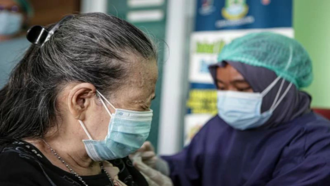 Arsip Foto. Petugas memberikan suntikan vaksin COVID-19 dosis penguat kepada warga lansia di Puskesmas Panunggangan Barat, Kota Tangerang, Provinsi Banten, Rabu (12/1/2022). (ANTARA FOTO/Fauzan/YU)