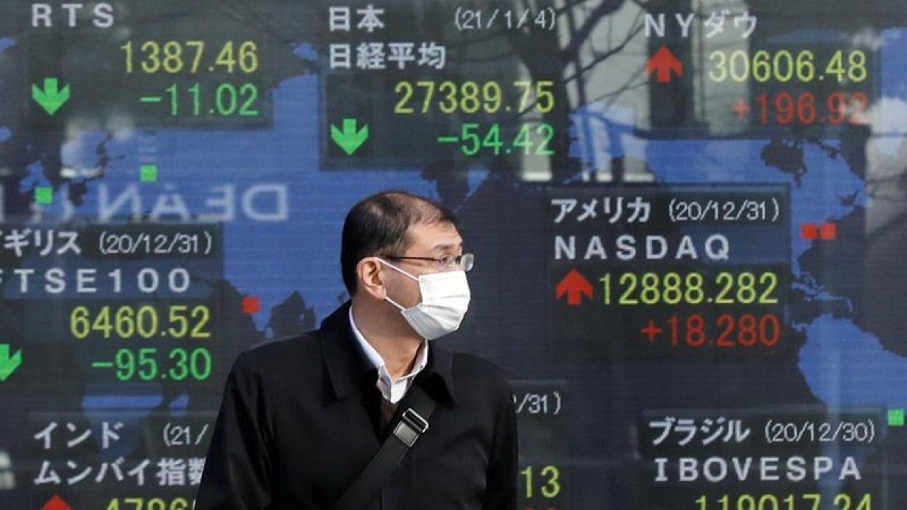 Pejalan kaki melintas di depan layar elektronik pergerakan Indeks Nikkei di Bursa Efek Tokyo, Jepang. ANTARA/REUTERS/Kim Kyung-Hoon/am.