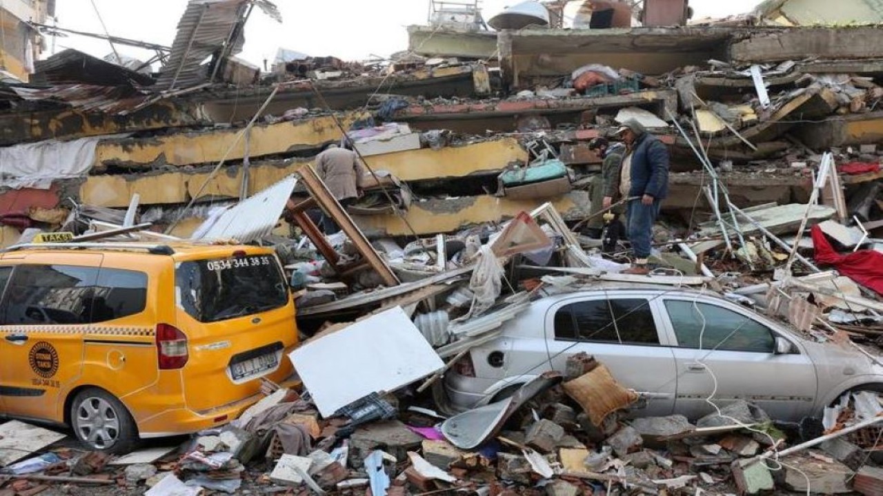 Orang-orang memeriksa kerusakan saat tim penyelamat mencari korban selamat setelah gempa yang mematikan di Hatay, Turki. (Umit Bektas/Reuters)