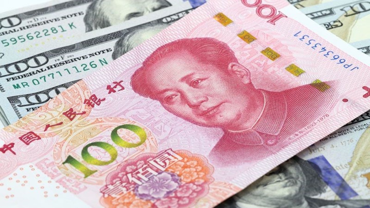 Ilustrasi - 100 yuan China di atas uang dolar AS. ANTARA/Shutterstock/pri.