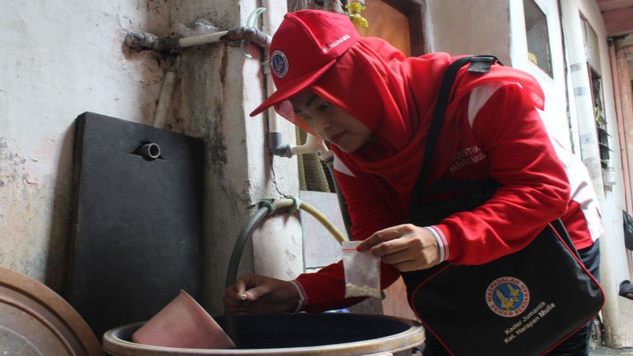 Seorang kader Juru Pemantau Jentik (Jumantik) memasukkan obat pemberantas jentik nyamuk ke dalam bak penampungan air di sebuah rumah warga di Kelurahan Harapan Mulya, Kemayoran, Jakarta Pusat, Rabu (27/7/2022). ANTARA FOTO/Andi Bagasela/wsj/nym.
