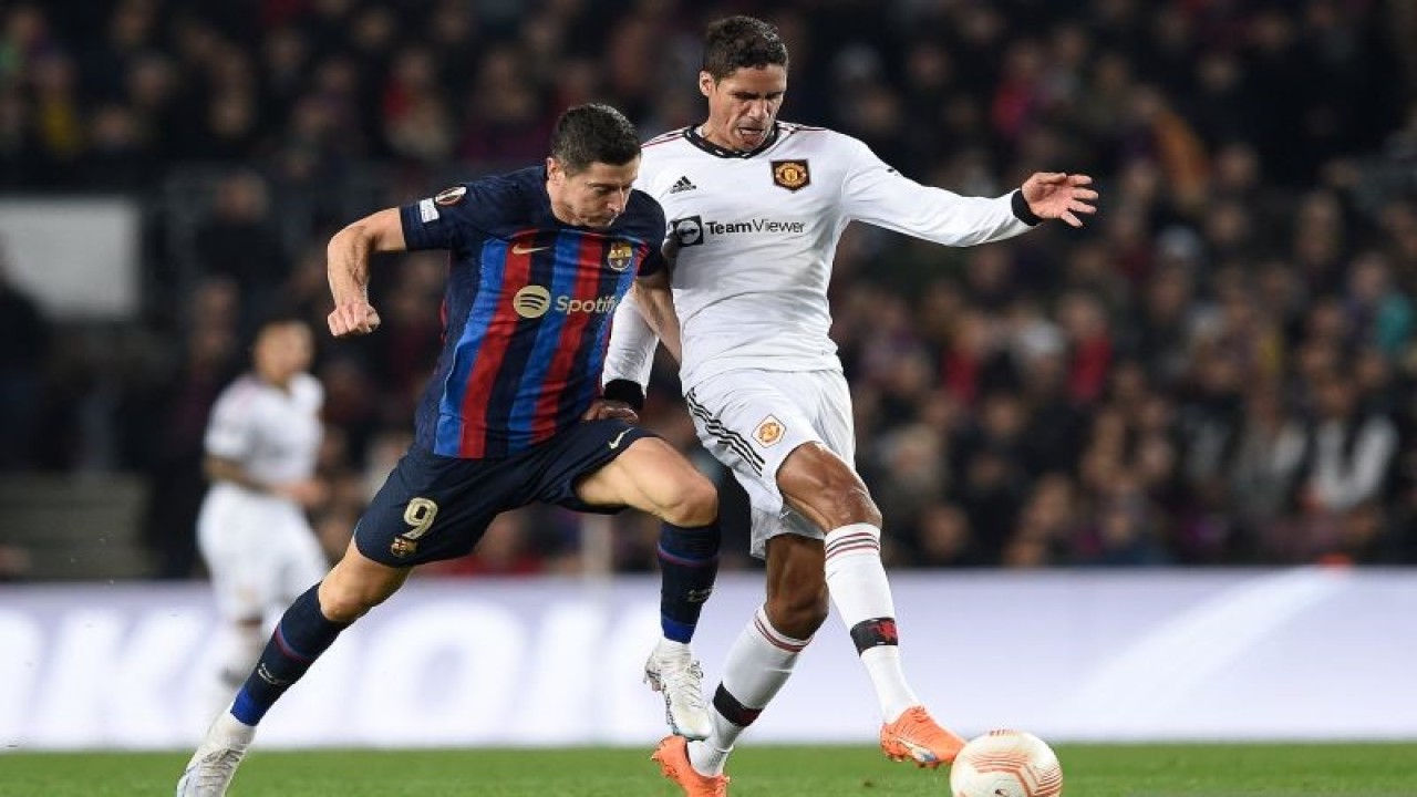Penyerang Barcelona Robert Lewandowski (kiri) berebut bola dengan bek Manchester United Raphael Varane dalam pertandingan leg pertama babak 32 besar Liga Europa di Camp Nou pada 16 Februari 2023. ANTARA/AFP/JOSEP LAGO