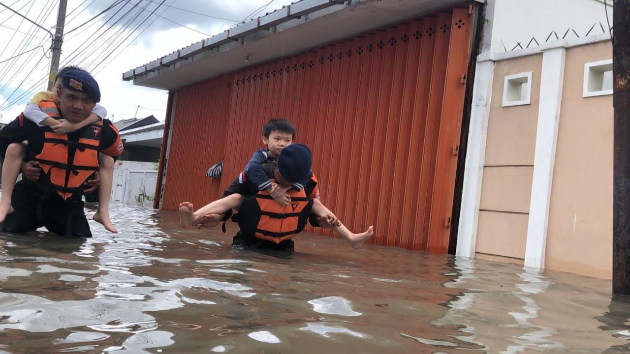 Petugas Brimob mengevakuasi warga yang terjebak banjir/ist