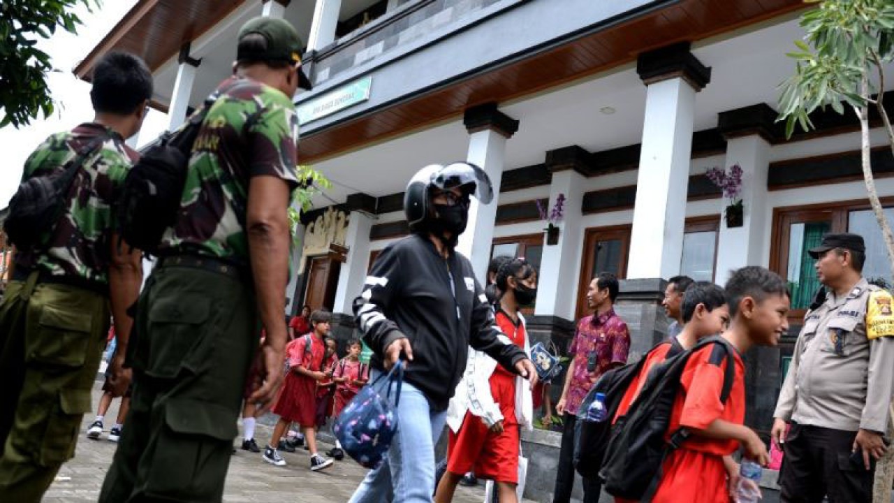 Polisi dan anggota Satuan Linmas membantu menjaga lingkungan sekolah di SD 3 Legian, Kabupaten Badung, Provinsi Bali, Selasa (7/2/2023). (ANTARA/Naufal Fikri Yusuf)