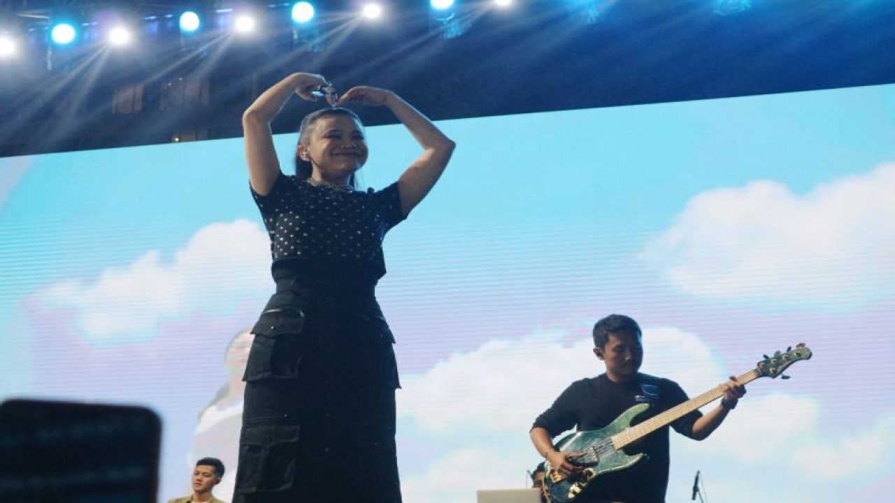 Diva Indonesia Rossa membentuk simbol hati dengan kedua tangannya di panggung festival Pasar Musik di Gambir Expo Kemayoran, Jakarta Utara, Minggu (12/2). (ANTARA/Pamela Sakina)