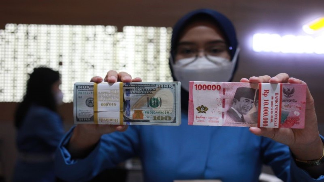 Petugas menunjukkan uang dolar AS dan uang rupiah di salah satu kantor cabang PT. Bank Mandiri Persero Tbk, Jakarta, Selasa (31/1/2023). ANTARA FOTO/Reno Esnir/tom. (ANTARA FOTO/RENO ESNIR)