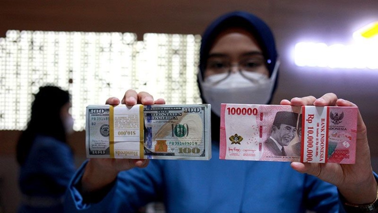 Ilustrasi - Petugas menunjukkan uang dolar AS dan uang rupiah di salah satu kantor cabang PT. Bank Mandiri Persero Tbk, Jakarta, Selasa (31/1/2023). ANTARA FOTO/Reno Esnir/tom/pri. (ANTARA FOTO/RENO ESNIR)