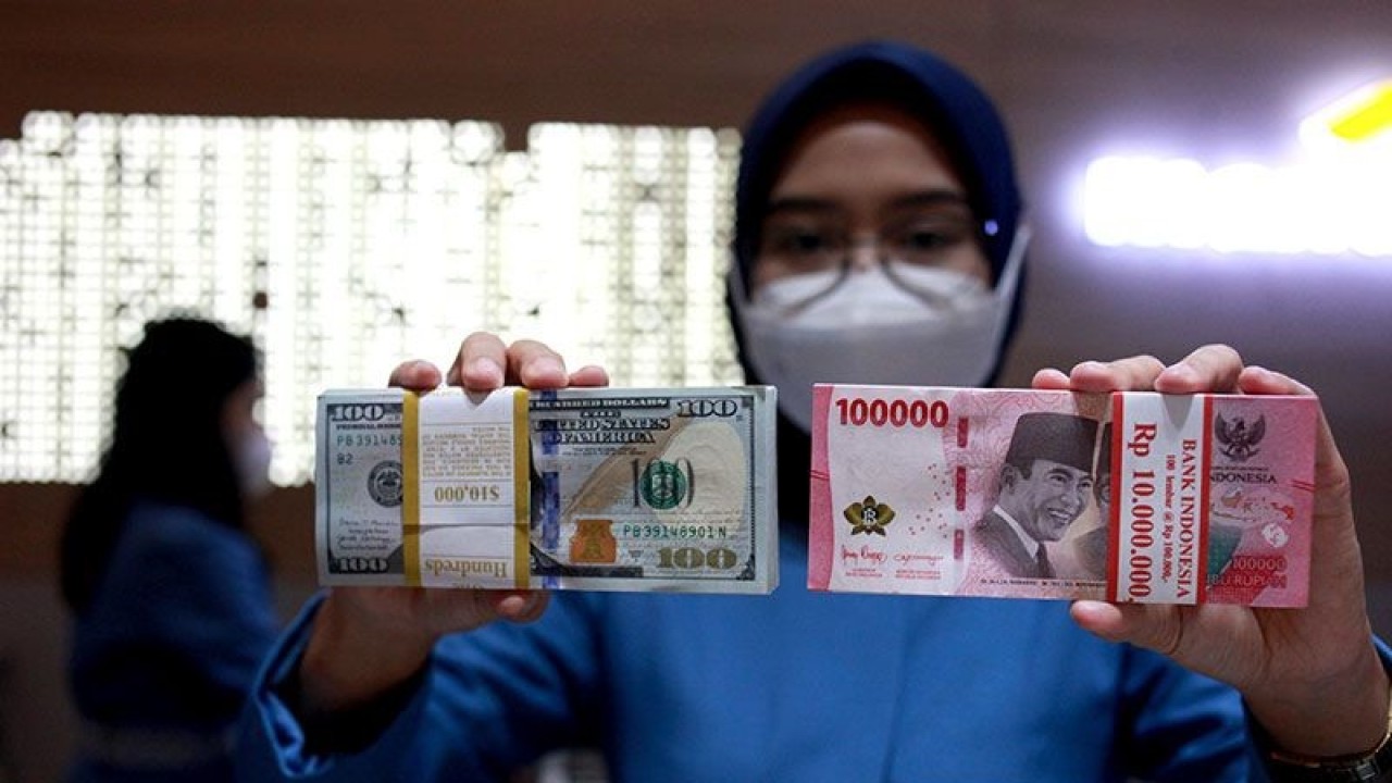 Ilustrasi - Petugas menunjukkan uang dolar AS dan uang rupiah di salah satu kantor cabang PT. Bank Mandiri Persero Tbk, Jakarta, Selasa (31/1/2023). ANTARA FOTO/Reno Esnir/tom/pri.