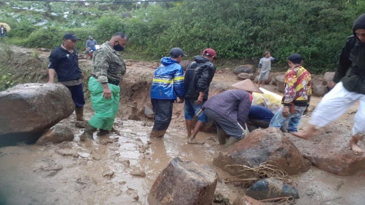 Sejumlah warga membersihkan material baru yang menutup badan jalan di Talegong, Kabupaten Garut, Jawa Barat, Kamis (30/3/2023). (ANTARA/HO-Diskominfo Garut)