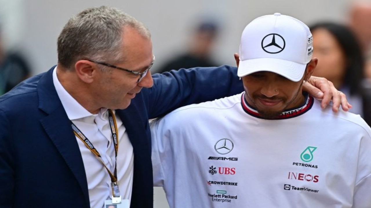 CEO Formula Satu Stefano Domenicali (kiri) berbicara dengan pebalap Mercedes Lewis Hamilton setela GP Monako di sirkuit Monako, 29 Mei 2022. (AFP/ANDREJ ISAKOVIC)
