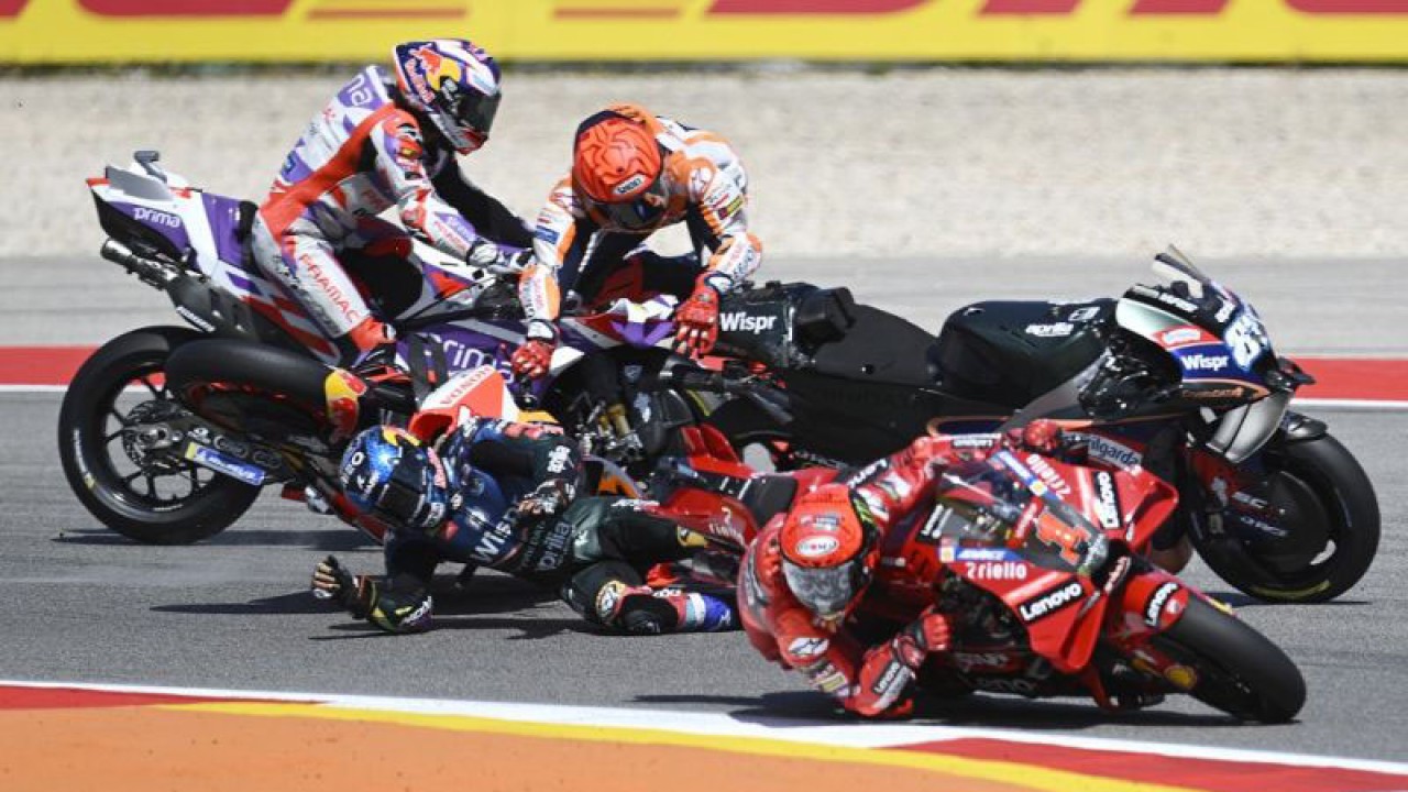 Marc Marquez dari Honda Repsol (tengah, atas) terlibat crash dengan pebalap CryptoDATA RNF Miguel Oliveira (tengah, bawah) saat pebalap Lenovo Ducati Francesco Bagnaia (depan) menyalip keduanya di sela MotoGP Portugal di Sirkuit Internasional Algarve Portimao, Portugal (26/3/2023). ANTARA/AFP/Patricia de Melo Moreira/aa. (AFP/PATRICIA DE MELO MOREIRA)