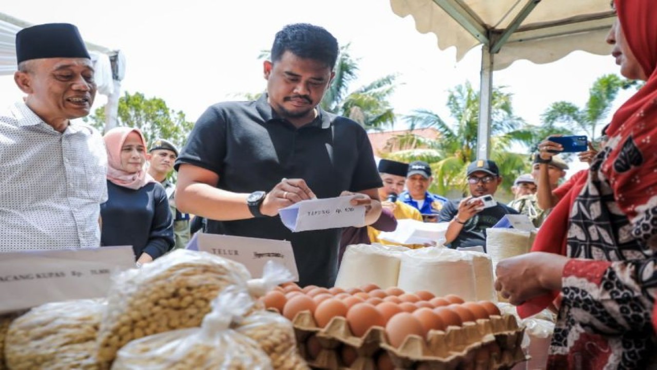 Wali Kota Medan Bobby Nasution (tengah) menuliskan harga bahan pokok di pasar murah menyambut bulan suci Ramadhan di Medan, Sabtu (18/3/2023). (ANTARA/HO-Diskominfo Kota Medan)
