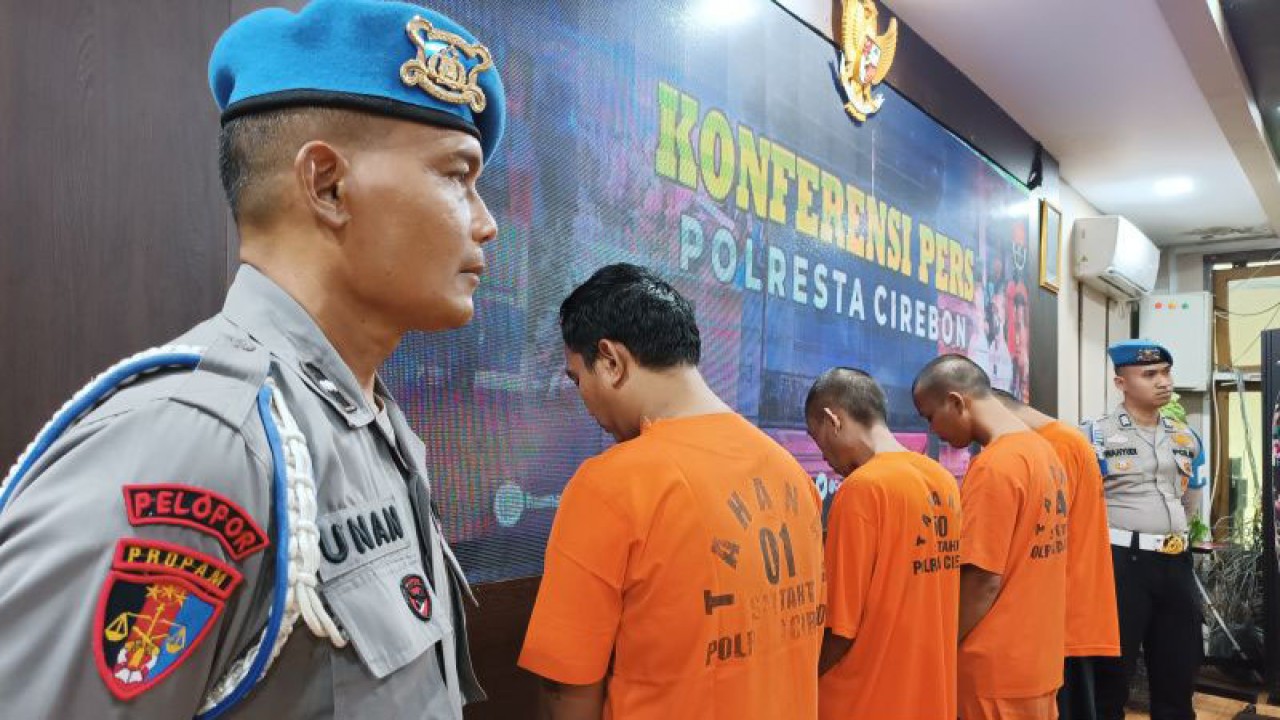 Petugas menjaga empat tersangka rampok saat ditunjukkan kepada media di Cirebon, Jawa Barat, Senin (27/3/2023). (ANTARA/Khaerul Izan)