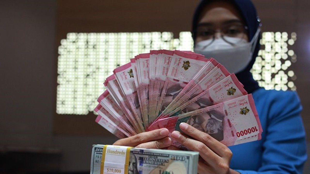 Petugas perbankan menunjukkan uang dolar AS dan uang rupiah, Jakarta, Selasa (31/1/2023). ANTARA FOTO/Reno Esnir/tom/aa. (ANTARA FOTO/RENO ESNIR)