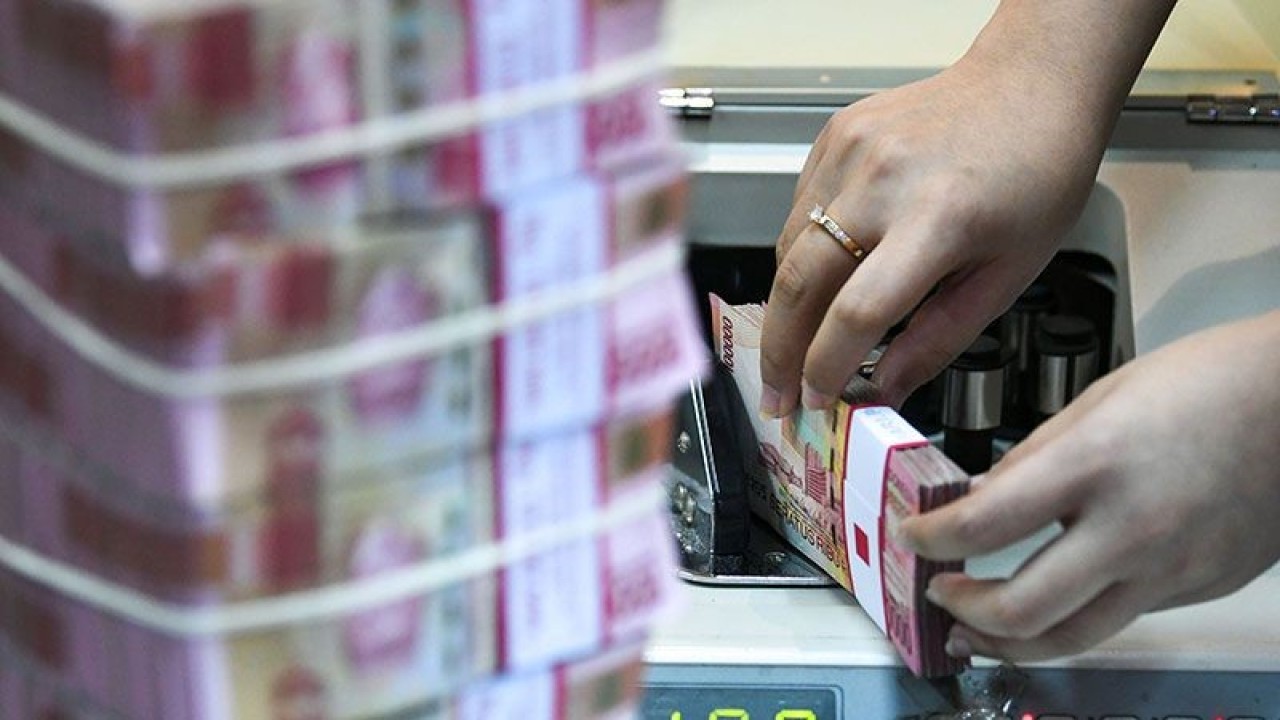 Seorang teller PT Bank Negara Indonesia (Persero) Tbk menghitung uang pecahan Rp100 ribu. ANTARA FOTO/M Risyal Hidayat/foc. (ANTARA FOTO/M RISYAL HIDAYAT)