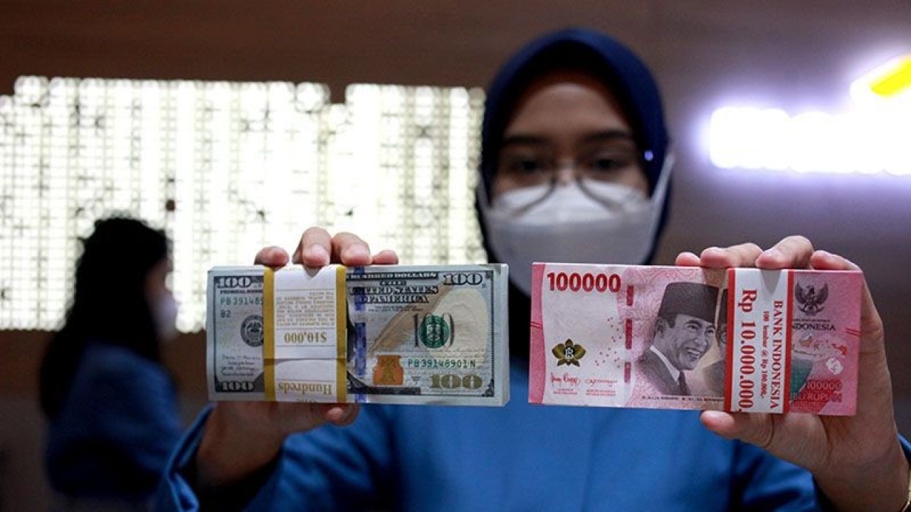 Ilustrasi - Petugas menunjukkan uang dolar AS dan uang rupiah di salah satu kantor cabang PT. Bank Mandiri Persero Tbk, Jakarta, Selasa (31/1/2023). ANTARA FOTO/Reno Esnir/tom/pri. (ANTARA FOTO/RENO ESNIR)