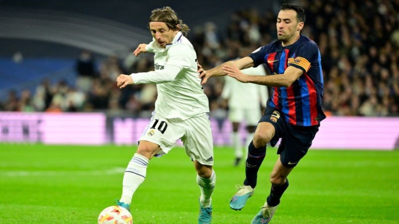 Luka Modric (kiri) dan Sergio Busquets (kanan) berduel memperebutkan bola dalam laga leg pertama semifinal Copa del Rey 2022-2023 antara Real Madrid vs Barcelona di Stadion Santiago Bernabeu pada 3 Maret 2023. ANTARA/AFP/JAVIER SORIANO
